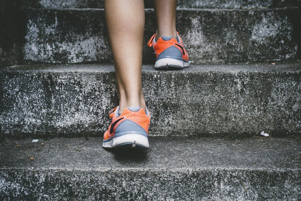 A person in running shoes climbing stairs outdoors